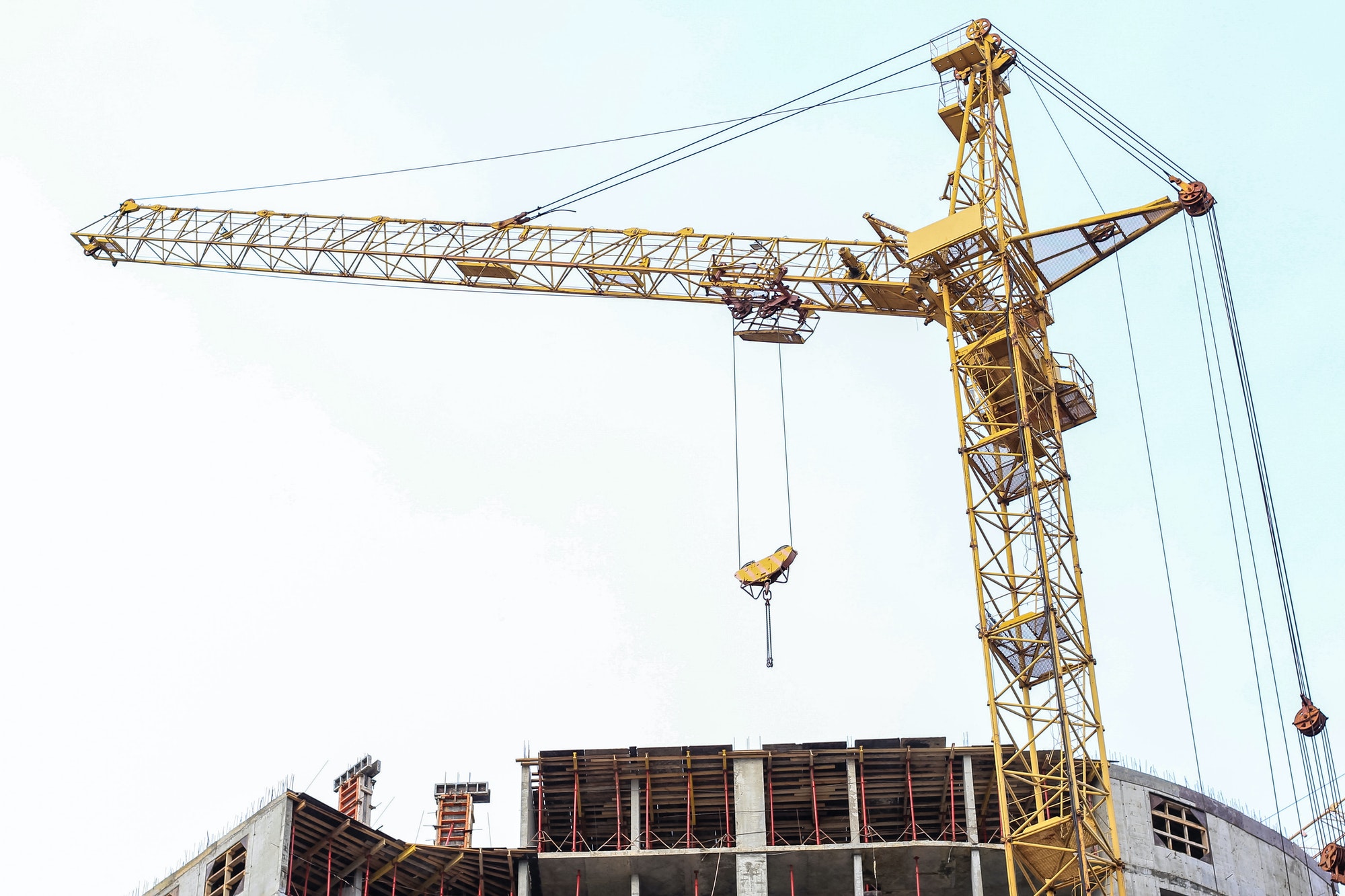 Construction crane stands on the background of the sky. Construction site. Tower crane.